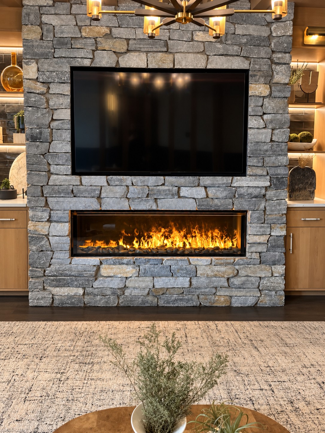 Warm linear fireplace set in a stone feature wall in a welcoming living space